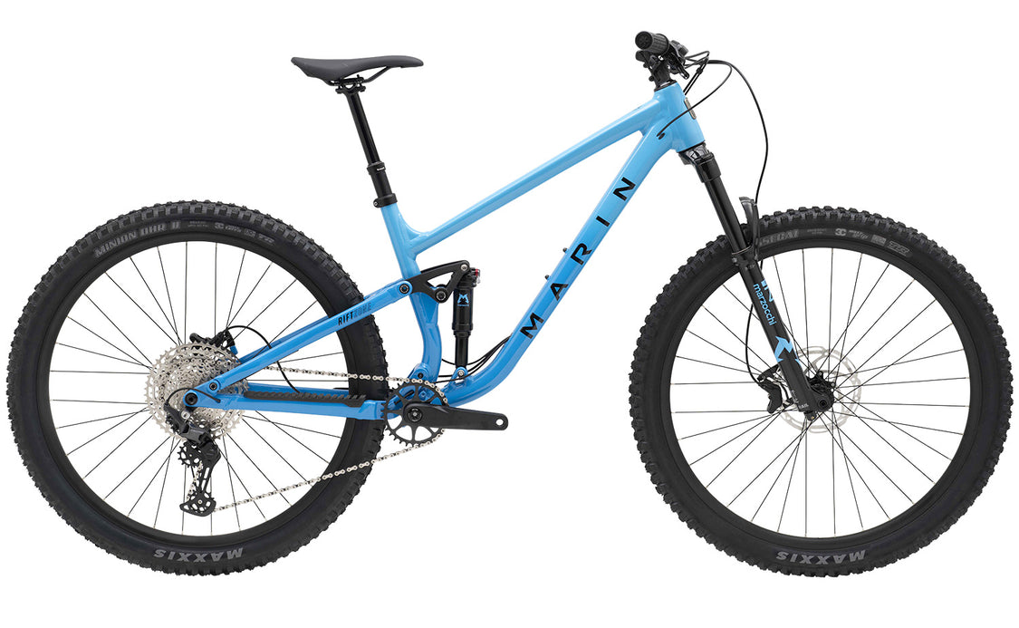 Blue mountain bike with Maxxis tires on a white background